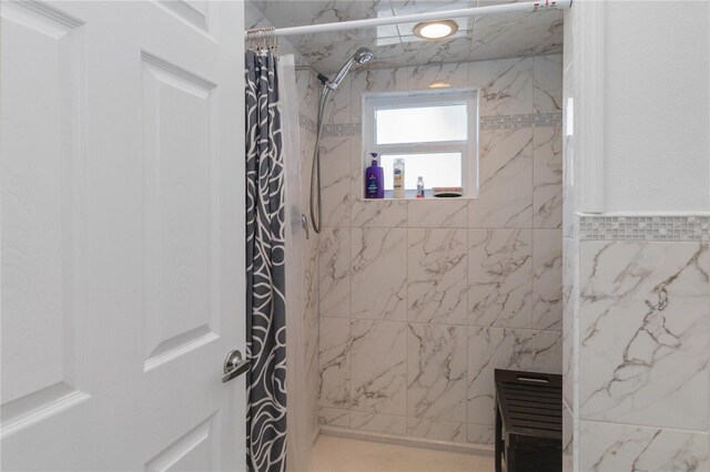 bathroom featuring curtained shower and tile walls