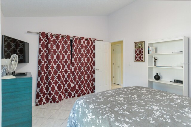 tiled bedroom featuring high vaulted ceiling