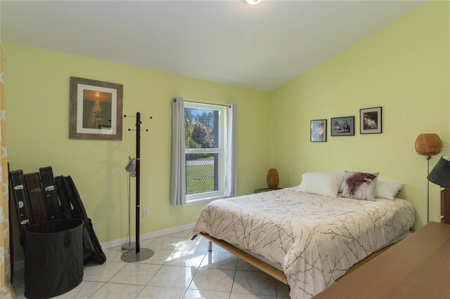 bedroom with light tile patterned floors and lofted ceiling