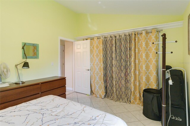 bedroom with light tile patterned floors and lofted ceiling