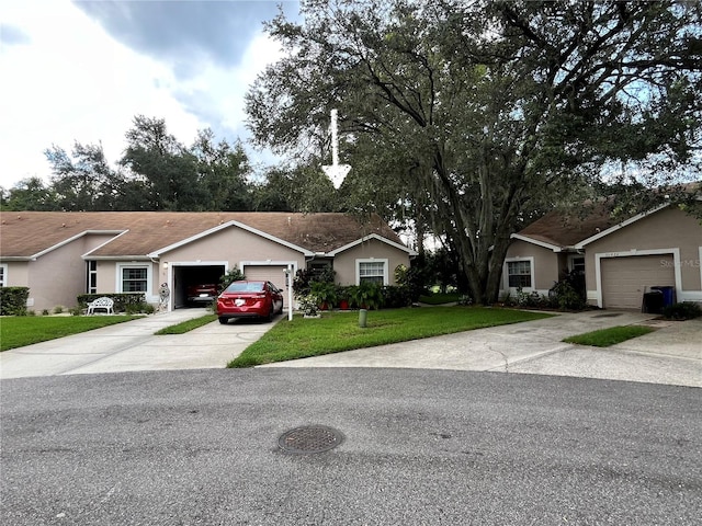 ranch-style house with a front yard, driveway, an attached garage, and stucco siding