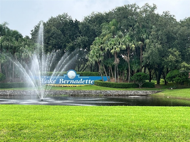 view of property's community with a water view and a yard