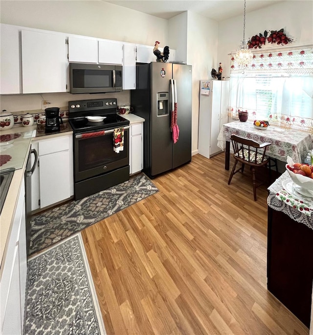 35226 Janine Dr, Zephyrhills, FL 33541 - kitchen featuring appliances with stainless steel finishes, light wood-type flooring, white cabinets, and light countertops