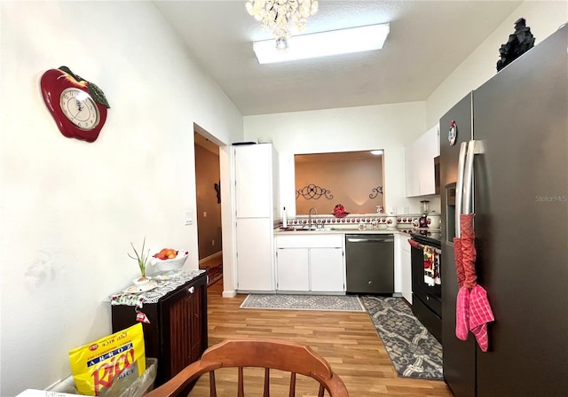 35226 Janine Dr, Zephyrhills, FL 33541 - kitchen with appliances with stainless steel finishes, light wood-style floors, light countertops, white cabinets, and a sink