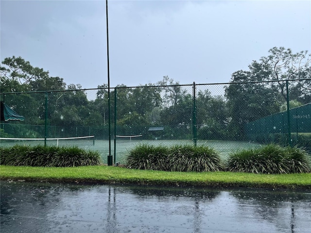 35226 Janine Dr, Zephyrhills, FL 33541 - view of tennis court with fence and a water view