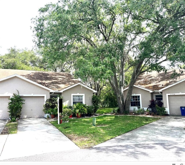 35226 Janine Dr, Zephyrhills, FL 33541 - ranch-style house featuring stucco siding, a front lawn, driveway, and a garage
