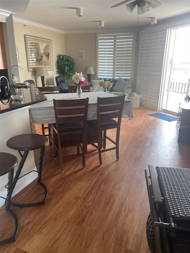 dining room featuring ceiling fan, crown molding, plenty of natural light, and hardwood / wood-style floors