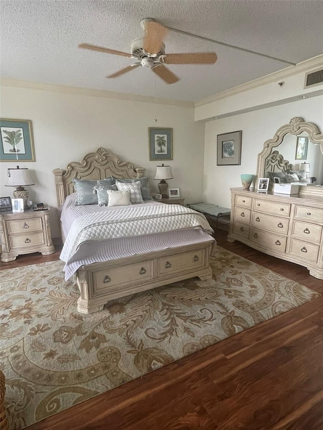 bedroom with crown molding, hardwood / wood-style floors, a textured ceiling, and ceiling fan