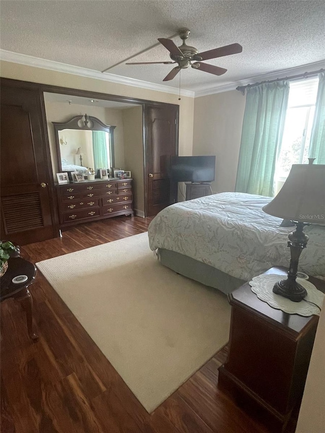 bedroom with ornamental molding, ceiling fan, a textured ceiling, and dark hardwood / wood-style flooring