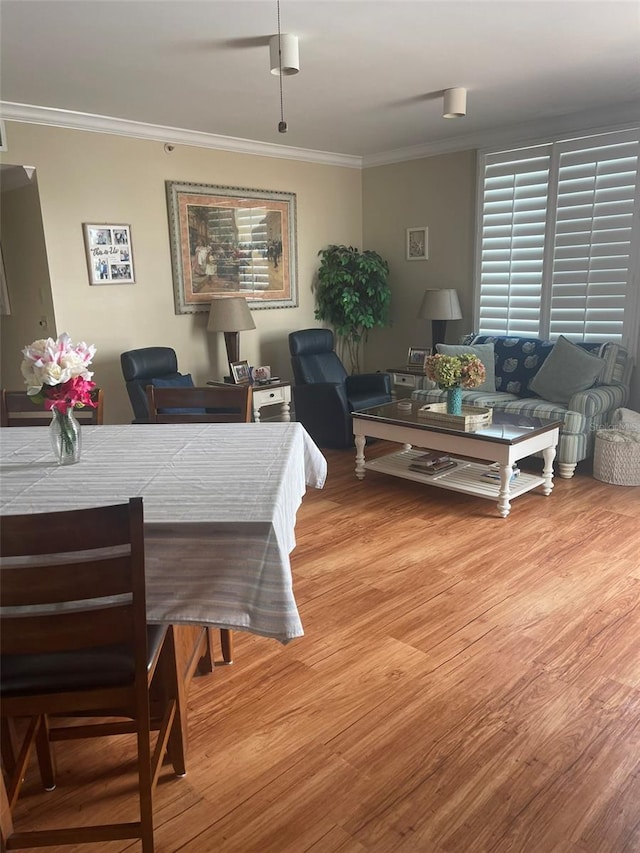 dining space with ornamental molding and wood-type flooring