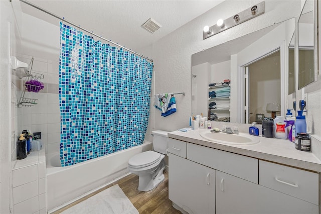 full bathroom with toilet, vanity, shower / bath combo, wood-type flooring, and a textured ceiling