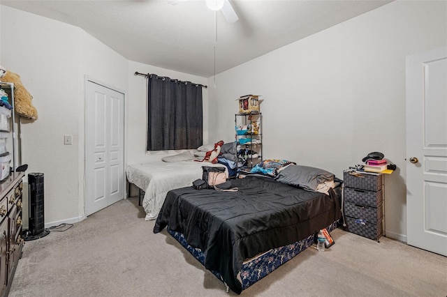 carpeted bedroom with ceiling fan and a closet