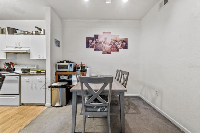 dining room with light wood-type flooring and ornamental molding