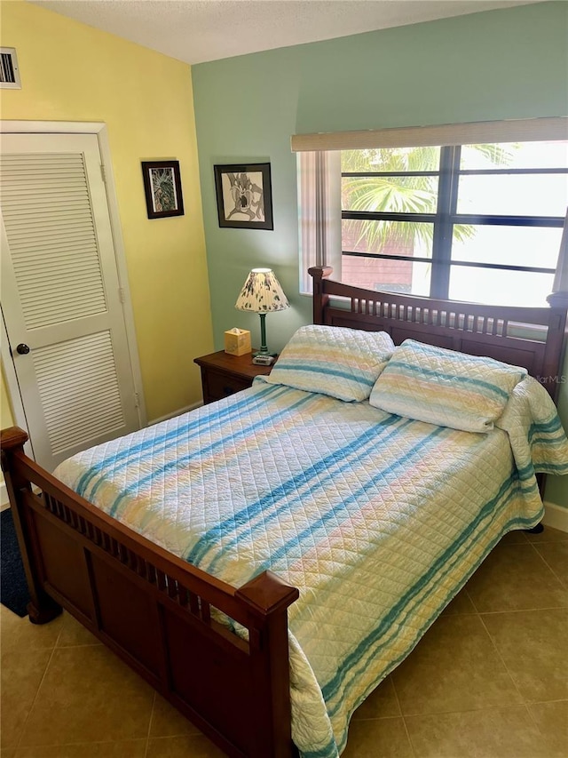 tiled bedroom featuring a closet