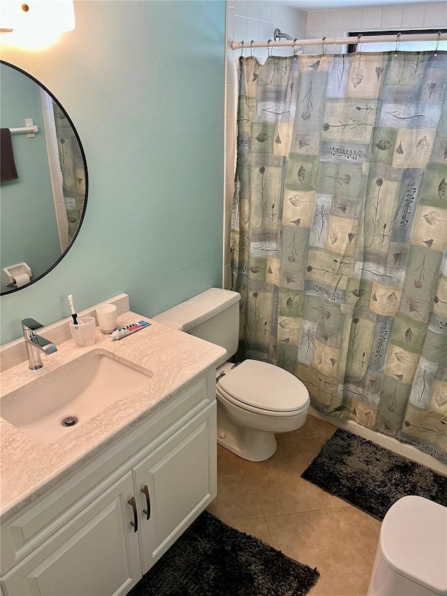 bathroom featuring curtained shower, toilet, vanity, and tile patterned floors