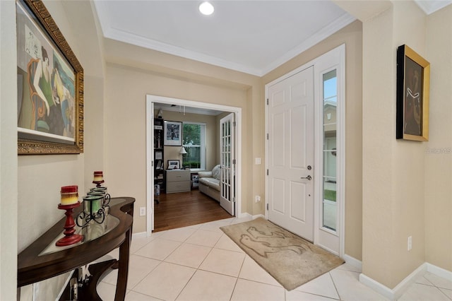 foyer entrance featuring light tile patterned floors and ornamental molding