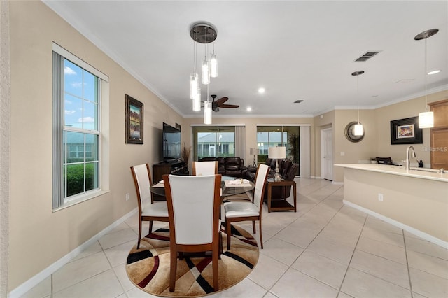 dining space with light tile patterned floors, ceiling fan, ornamental molding, and sink