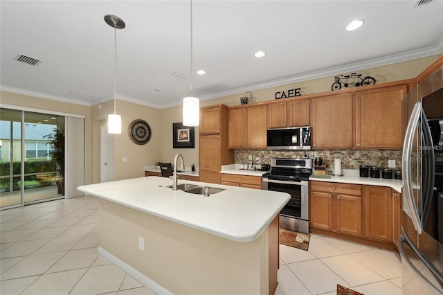 kitchen with decorative backsplash, stainless steel appliances, sink, hanging light fixtures, and an island with sink