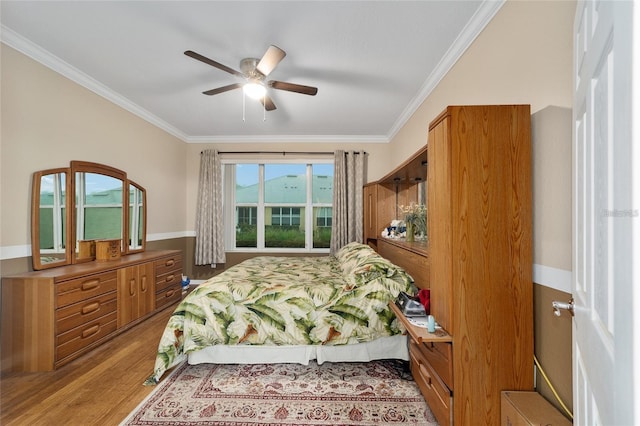 bedroom featuring ceiling fan, crown molding, and light hardwood / wood-style floors