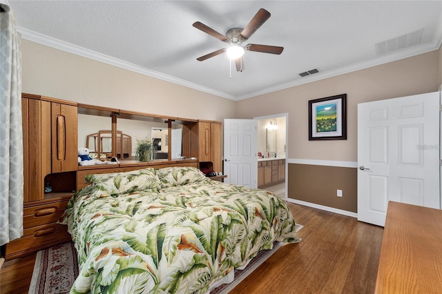 bedroom featuring connected bathroom, ceiling fan, dark hardwood / wood-style floors, and ornamental molding