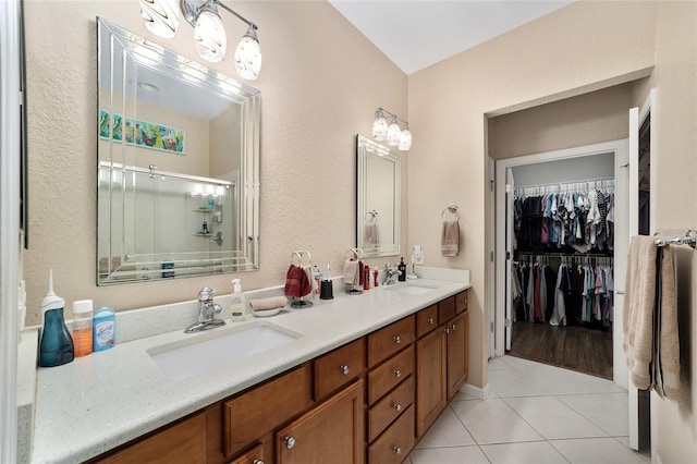 bathroom with tile patterned floors, a shower with door, and vanity