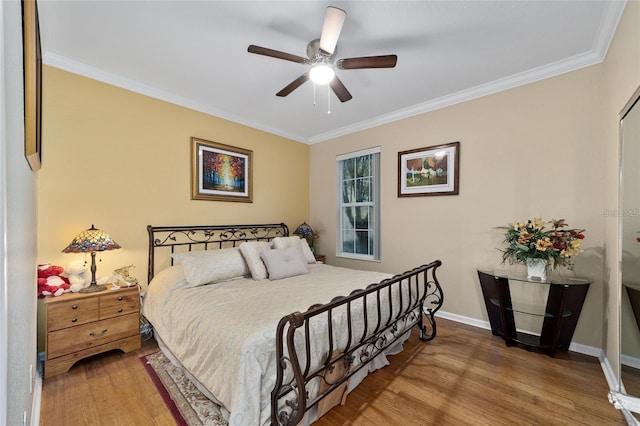 bedroom featuring ceiling fan, hardwood / wood-style floors, and crown molding