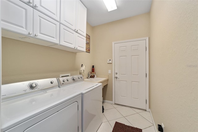 clothes washing area with cabinets, washing machine and dryer, sink, and light tile patterned flooring