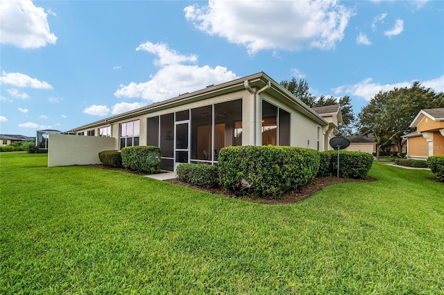 back of property with a sunroom and a yard