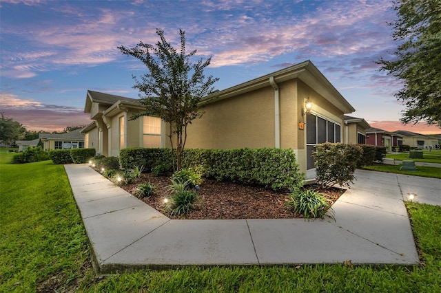 property exterior at dusk with a yard