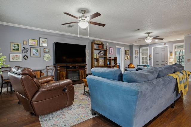 living room with a textured ceiling, dark hardwood / wood-style flooring, ceiling fan, and crown molding