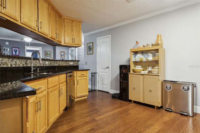 kitchen with sink, a textured ceiling, stainless steel dishwasher, and dark stone countertops