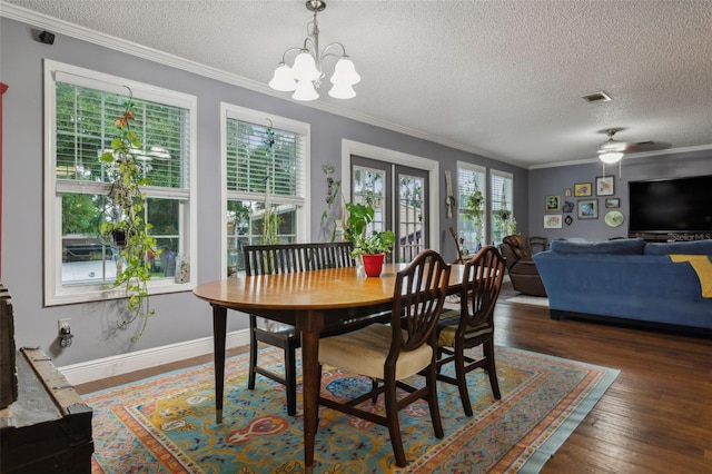 dining room with a wealth of natural light, crown molding, dark wood-type flooring, and ceiling fan with notable chandelier