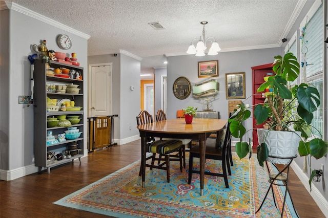 dining space featuring a textured ceiling, crown molding, dark hardwood / wood-style floors, and a notable chandelier