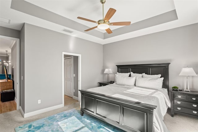 bedroom featuring carpet flooring, a tray ceiling, and ceiling fan