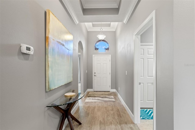 entryway with light hardwood / wood-style flooring and crown molding