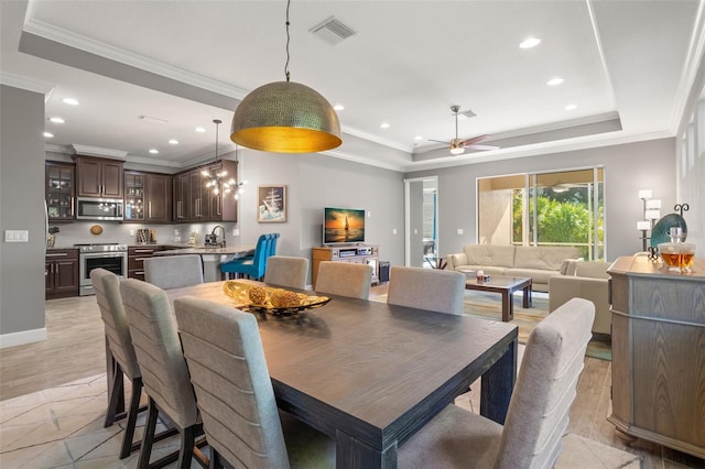 dining space with a tray ceiling, ceiling fan, crown molding, and light hardwood / wood-style floors