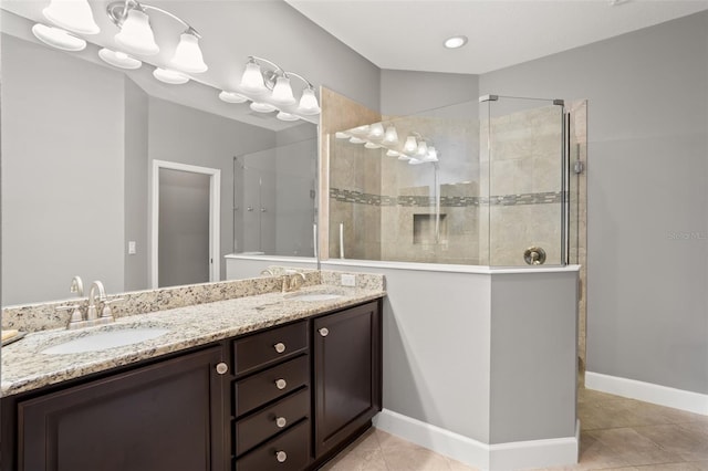 bathroom featuring tile patterned floors, vanity, and a tile shower