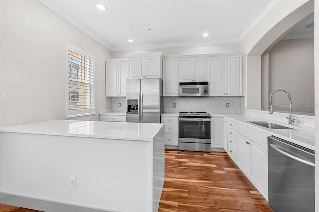 kitchen with tasteful backsplash, light wood-type flooring, sink, appliances with stainless steel finishes, and kitchen peninsula