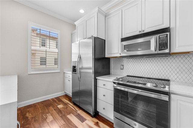 kitchen featuring decorative backsplash, white cabinets, hardwood / wood-style floors, crown molding, and appliances with stainless steel finishes