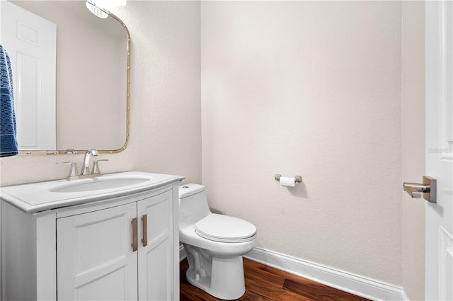 bathroom with vanity, hardwood / wood-style flooring, and toilet