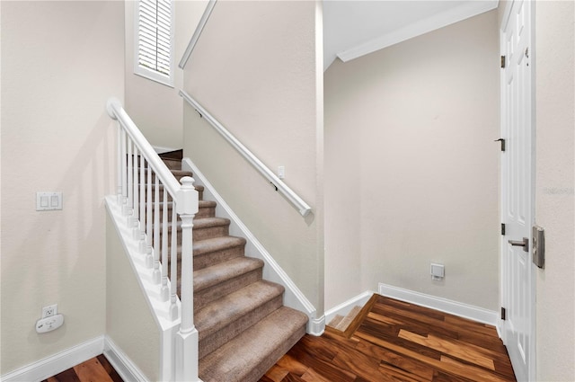 staircase with dark hardwood / wood-style floors and ornamental molding