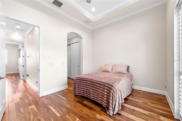 bedroom with ceiling fan, crown molding, hardwood / wood-style flooring, and a closet