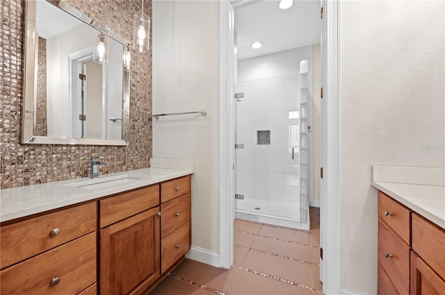 bathroom featuring tile patterned flooring, decorative backsplash, vanity, and a tile shower