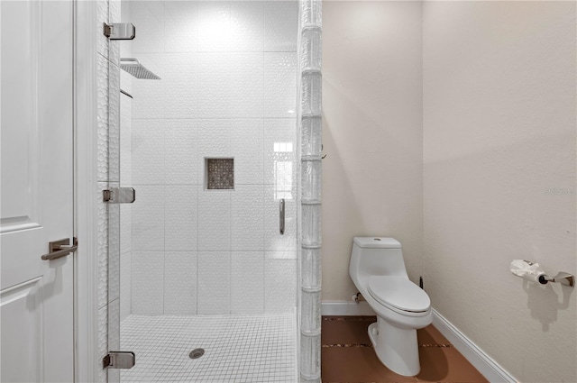 bathroom with a tile shower and toilet