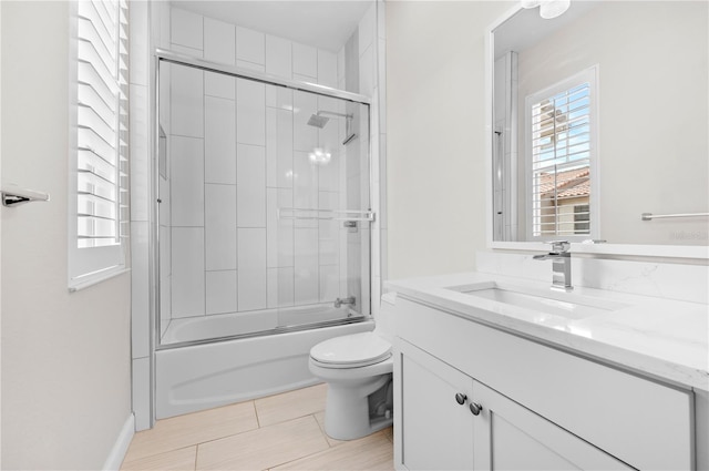 full bathroom featuring vanity, tile patterned flooring, bath / shower combo with glass door, and toilet