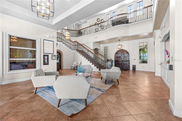 interior space featuring an inviting chandelier, tile patterned flooring, and a towering ceiling