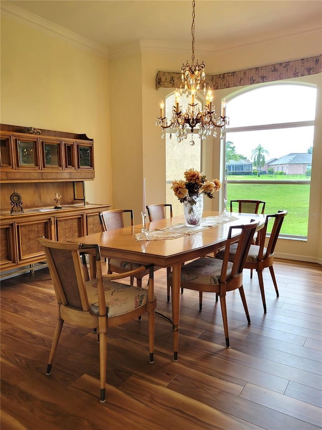 dining area featuring dark hardwood / wood-style flooring, crown molding, and a notable chandelier