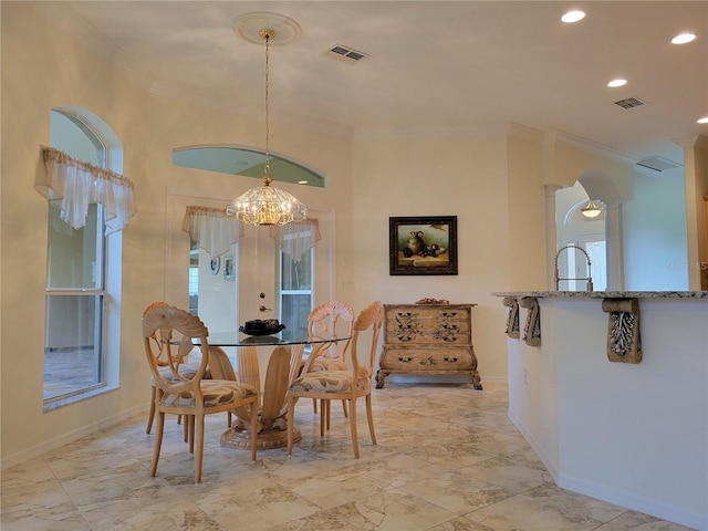 dining room featuring decorative columns, a notable chandelier, french doors, crown molding, and sink