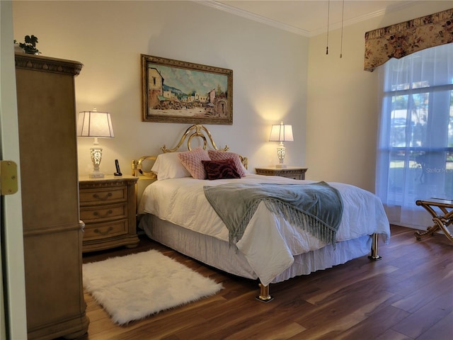 bedroom with dark hardwood / wood-style flooring and crown molding