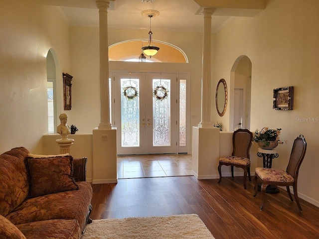 entrance foyer featuring a healthy amount of sunlight, french doors, decorative columns, and hardwood / wood-style flooring